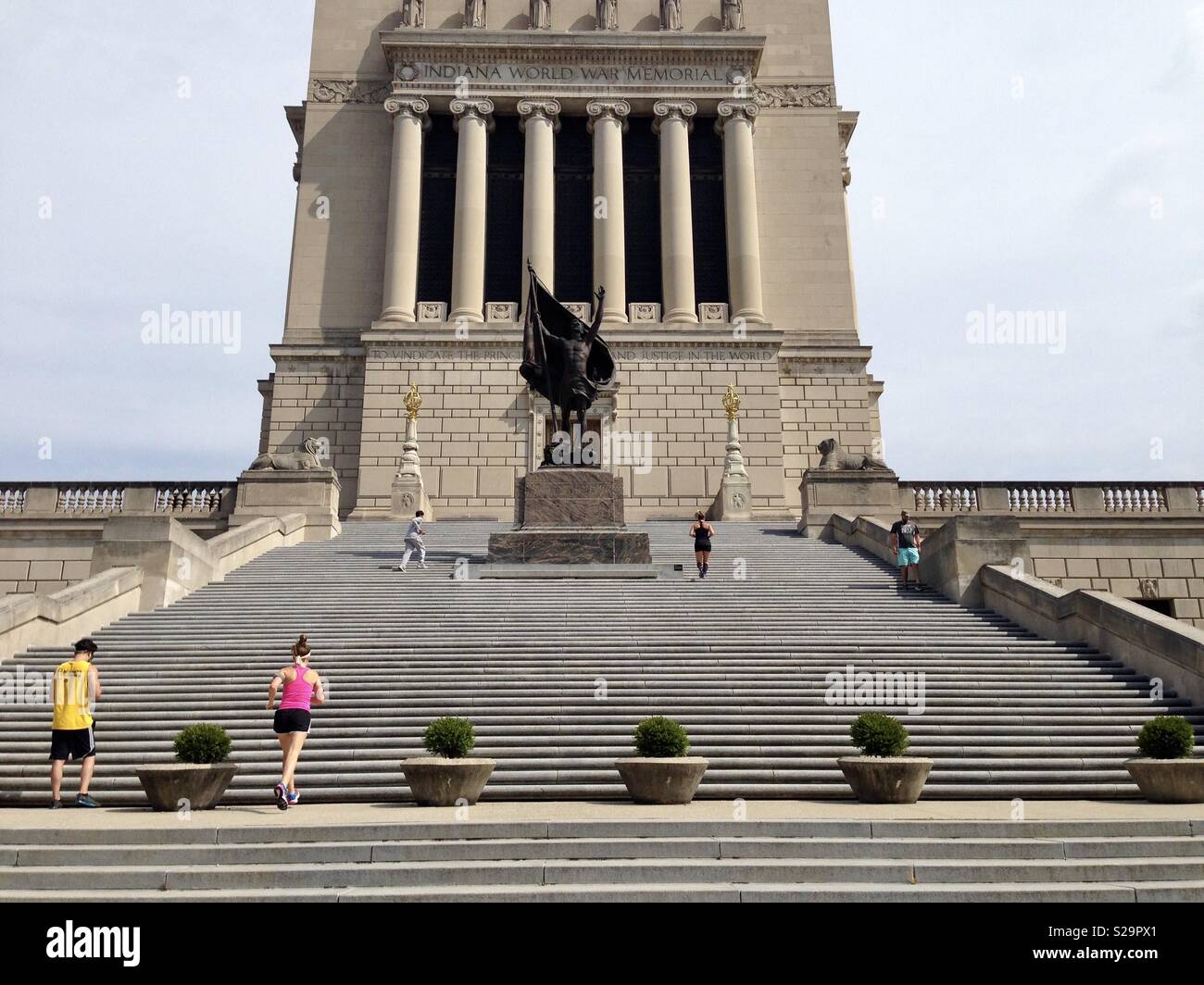 Jogger auf die Schritte der Indiana Weltkrieg Memorial, in Indianapolis, Indiana Stockfoto