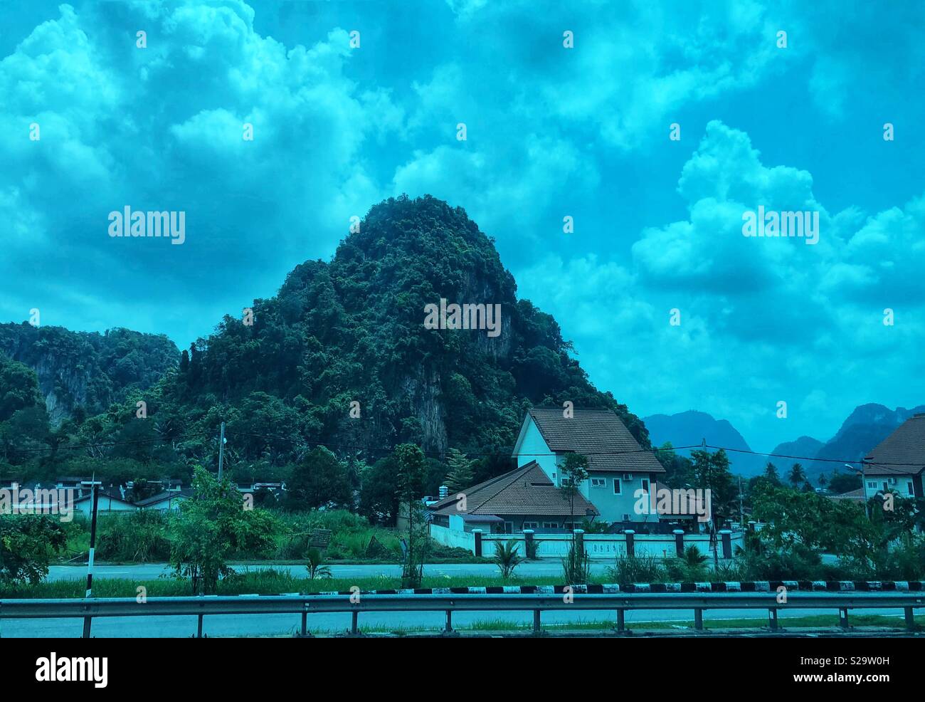 Malaysische Landschaft durch eine getönte Fenster eines fahrenden Bus gesehen. Stockfoto