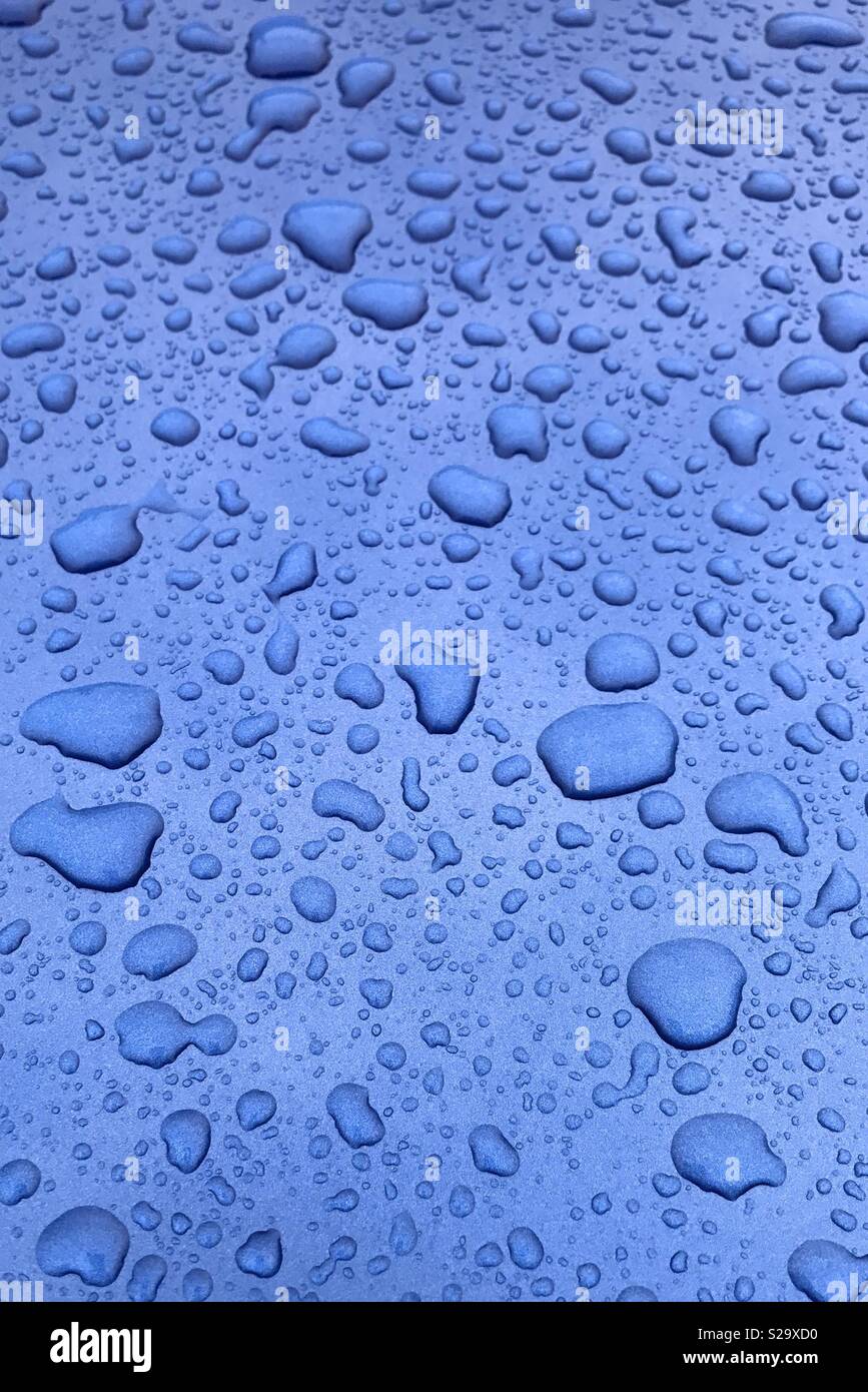 Wassertropfen auf Blau metallic Oberfläche Stockfoto