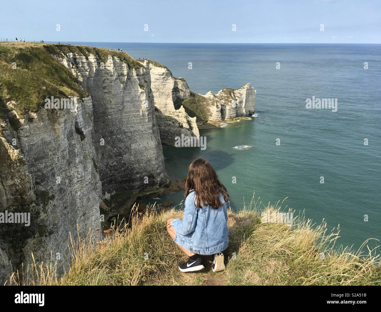 Junges Mädchen am Rande einer Klippe in Etretat Frankreich Stockfoto