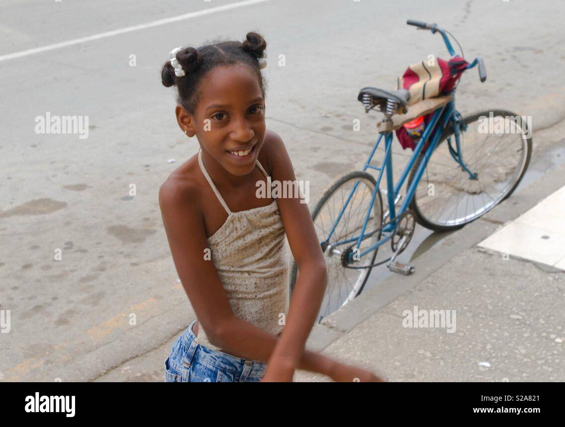 Junge smiley Mädchen und ihre blauen Fahrrad in Havanna Kuba Stockfoto
