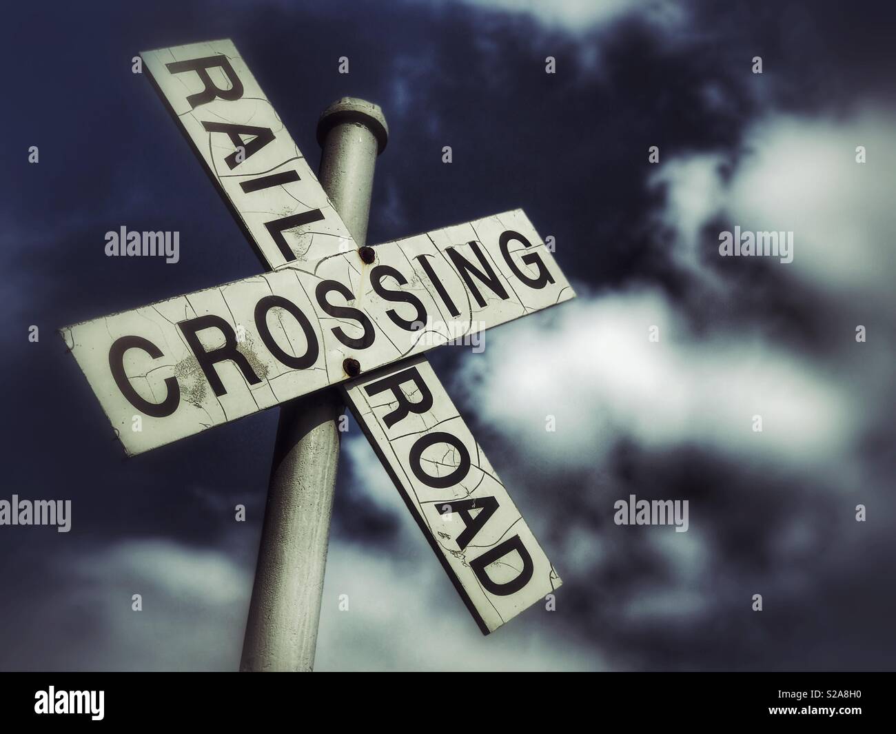 Bahnübergang mit geschwollenen Wolken im Hintergrund - Smartphone-aufgenommenes Stockfoto