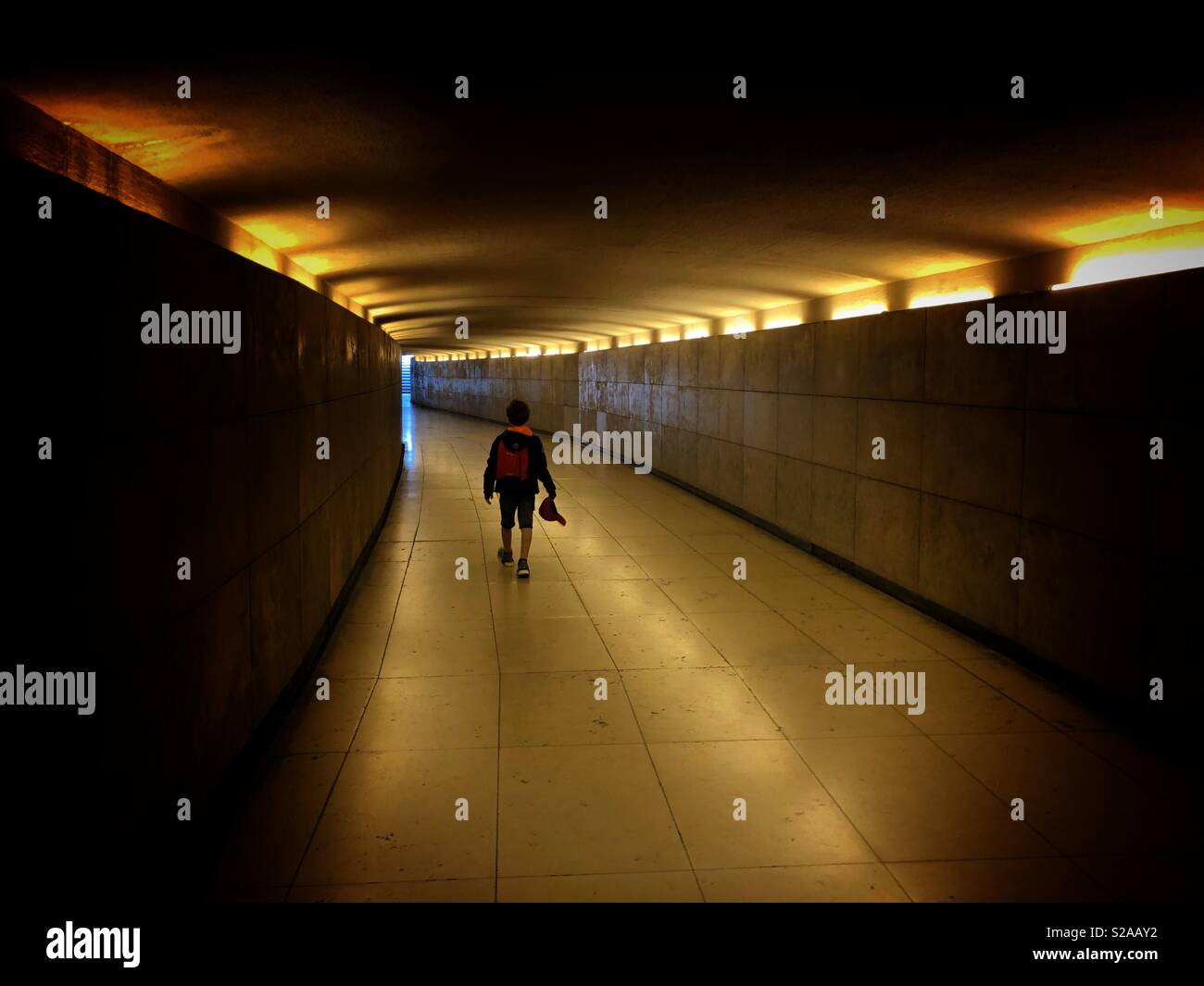 Junge allein einen Tunnel mit Beleuchtung Stockfoto