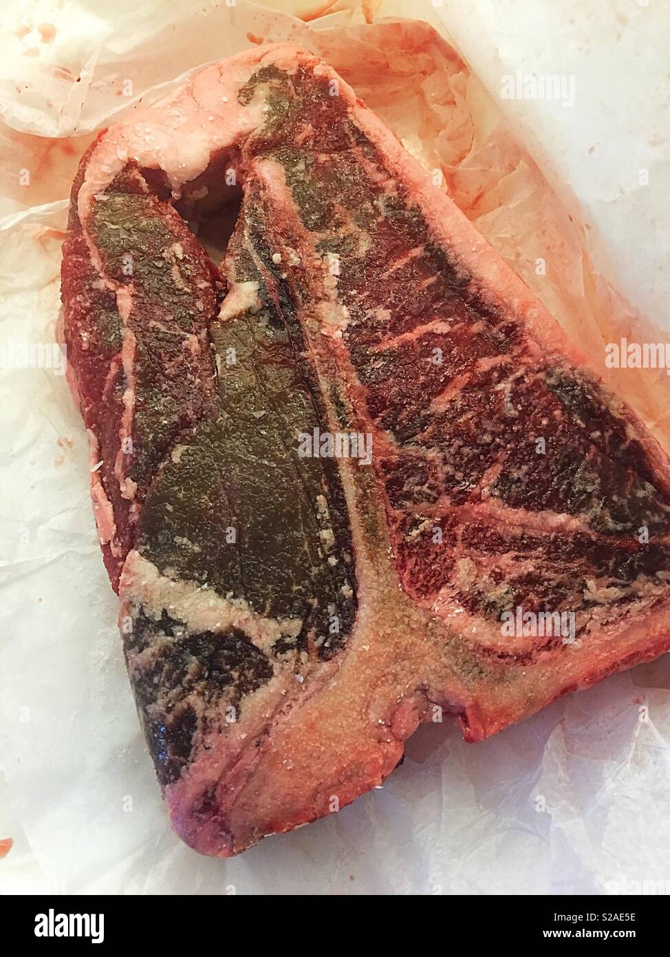 Nahaufnahme einer Raw-T-Bone Steak auf dem Metzgerpapier, USA Stockfoto