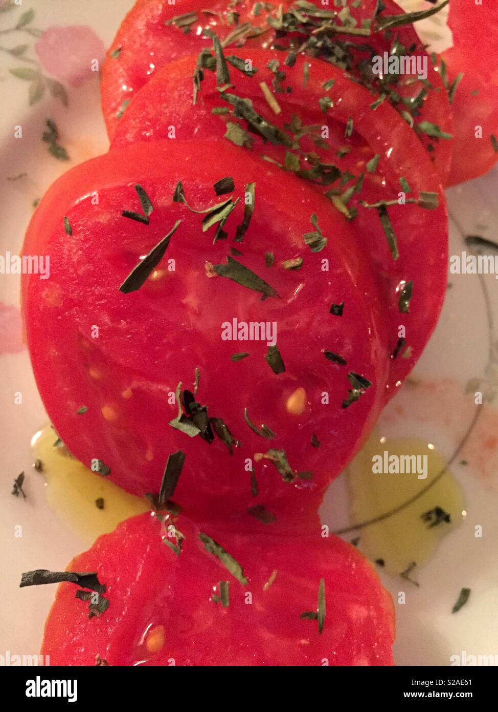 Noch immer leben von in Scheiben geschnittenen Tomaten und Kräutern auf einem China Platte, USA Stockfoto