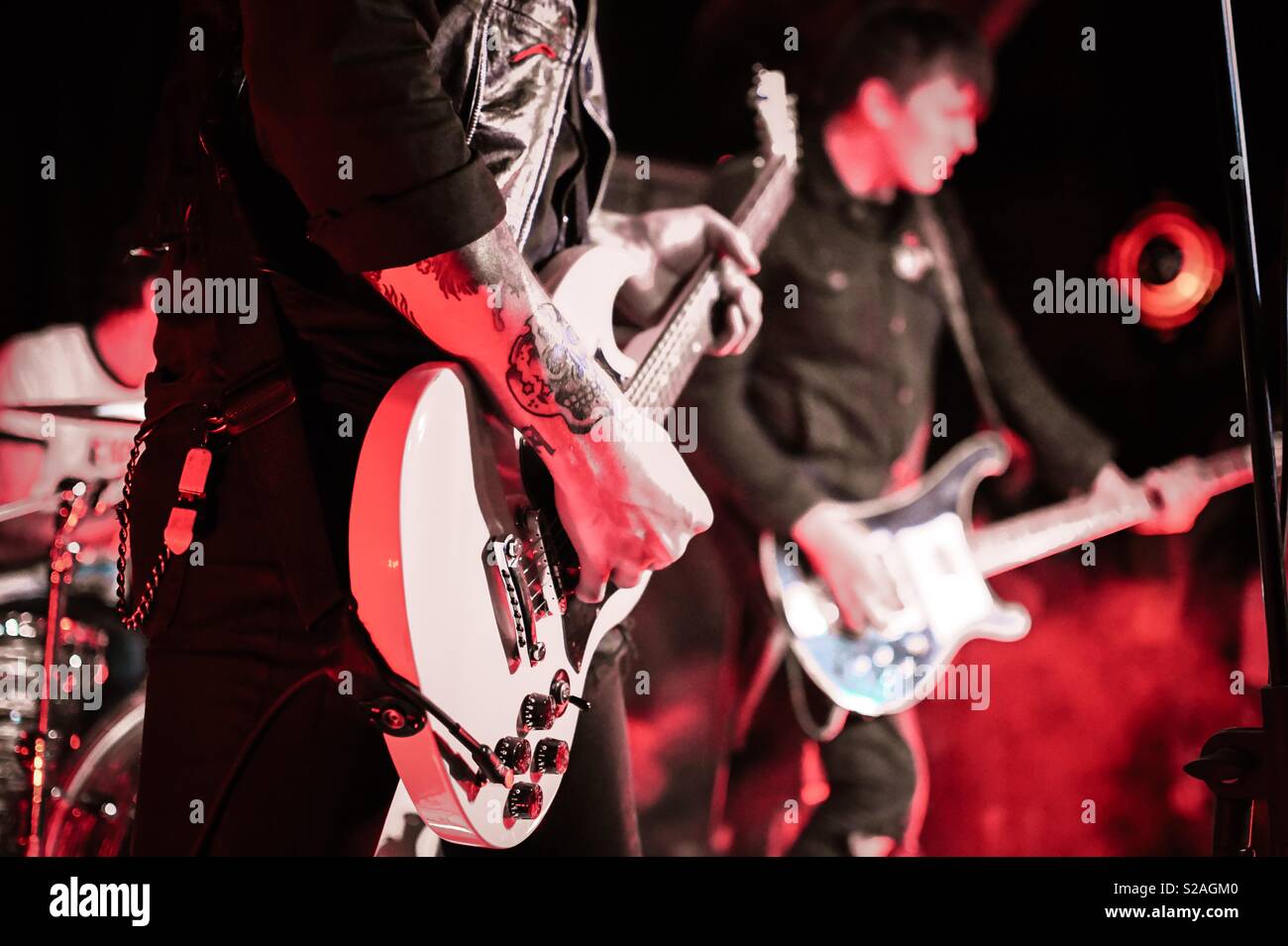 Gitarristen in einer Punk Band auf der Bühne bei einem Konzert. Gitarre und tätowiert Arm Stockfoto