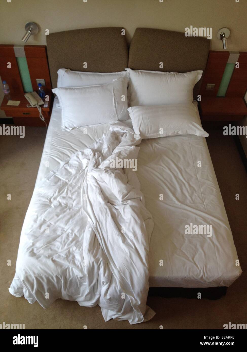 Bett im Hotelzimmer rückgängig gemacht Stockfoto