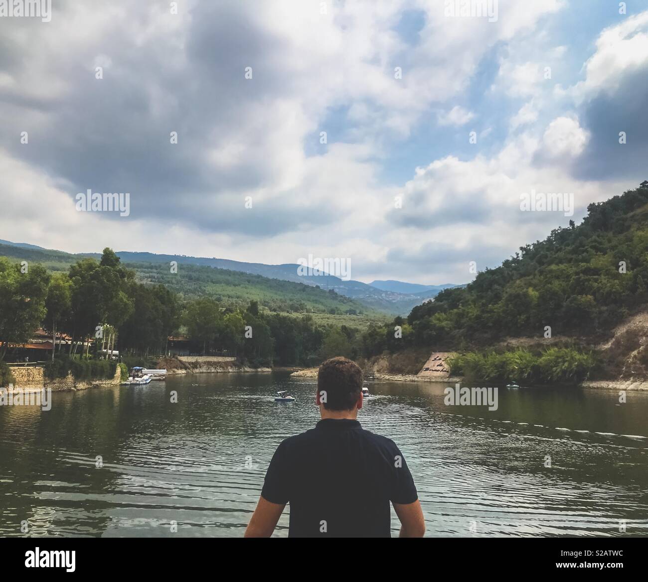 Tausendjährigen Mann von der Rückseite vor schönen See und Bergblick Stockfoto
