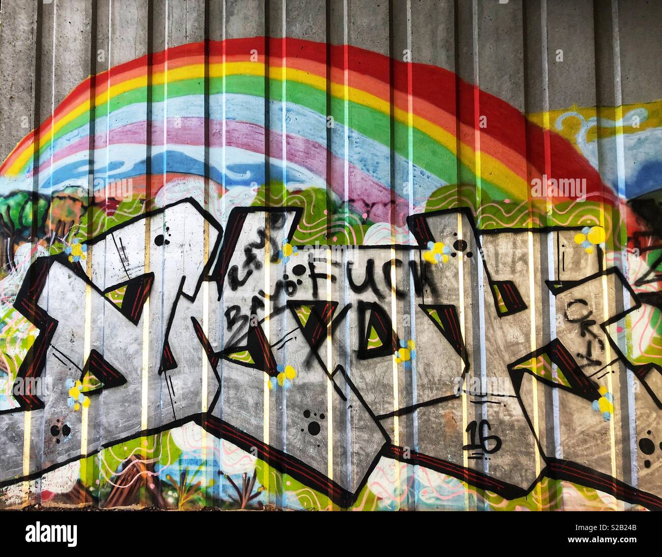 Graffiti an einer Wand unter eine zweispurige Straße. Stockfoto