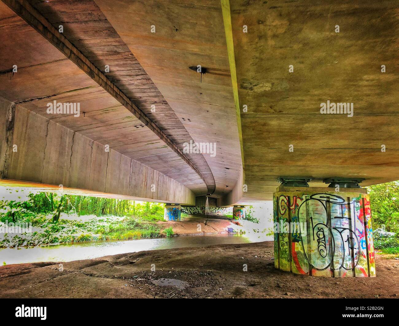 Graffiti unter einer Brücke über einen Fluss. Stockfoto