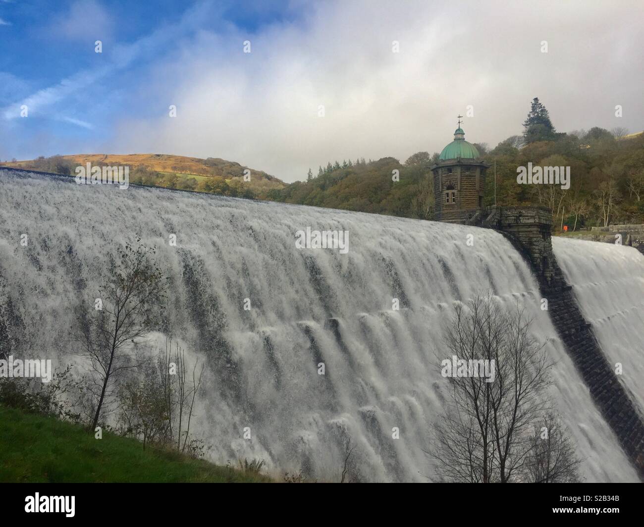 Elan Valley Dam, weißes Wasser über den Rand hetzen, blauer Himmel. Stockfoto