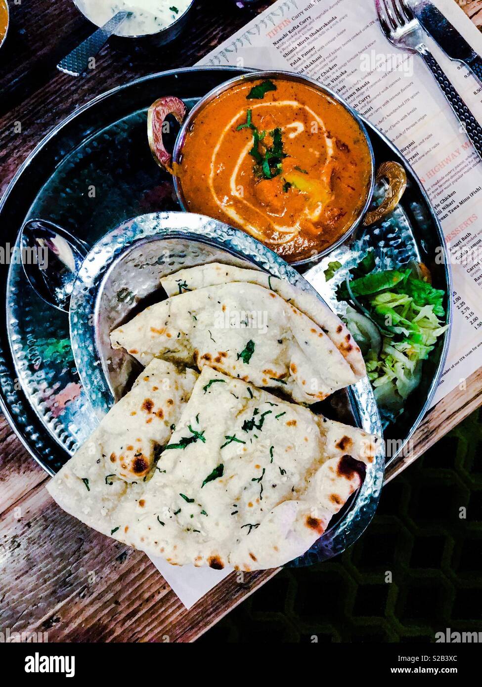 Im südlichen Indischen Butter Chicken Curry mit Knoblauch Naan Brot auf silbertablett Stockfoto