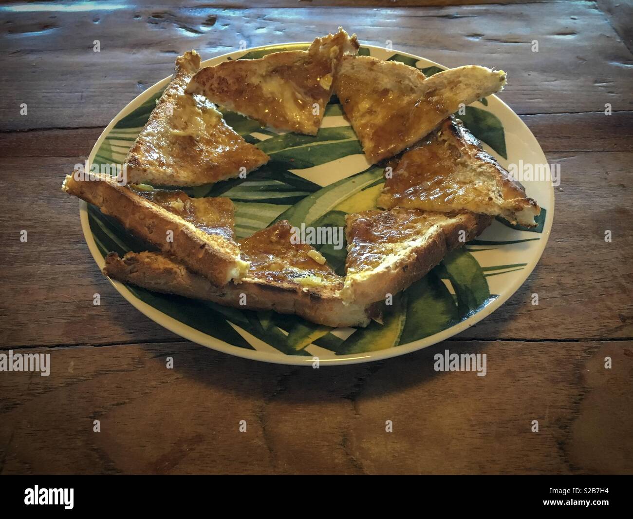 Eine Platte der Toast mit Butter und golden Sirup auf einem rustikalen Holztisch Stockfoto