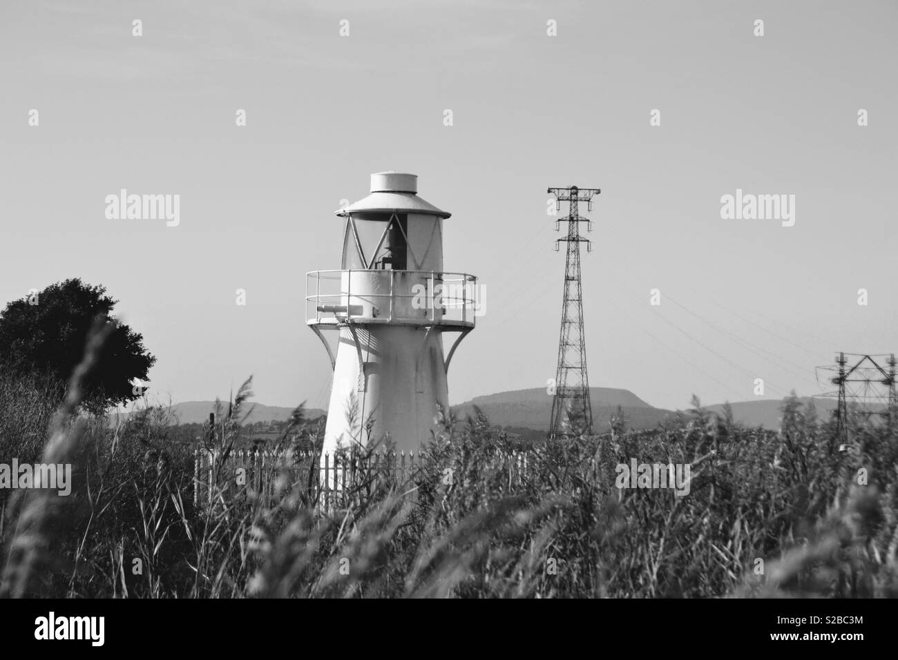 B&W Leuchtturm Szene mit Bergen Stockfoto