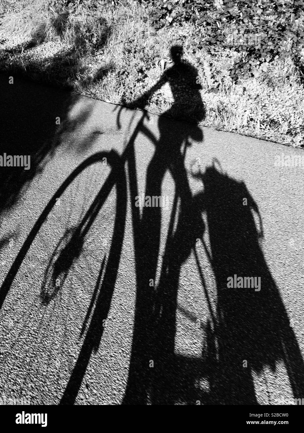 Schatten der ein Radfahrer auf einem Radweg in Cardiff. Stockfoto
