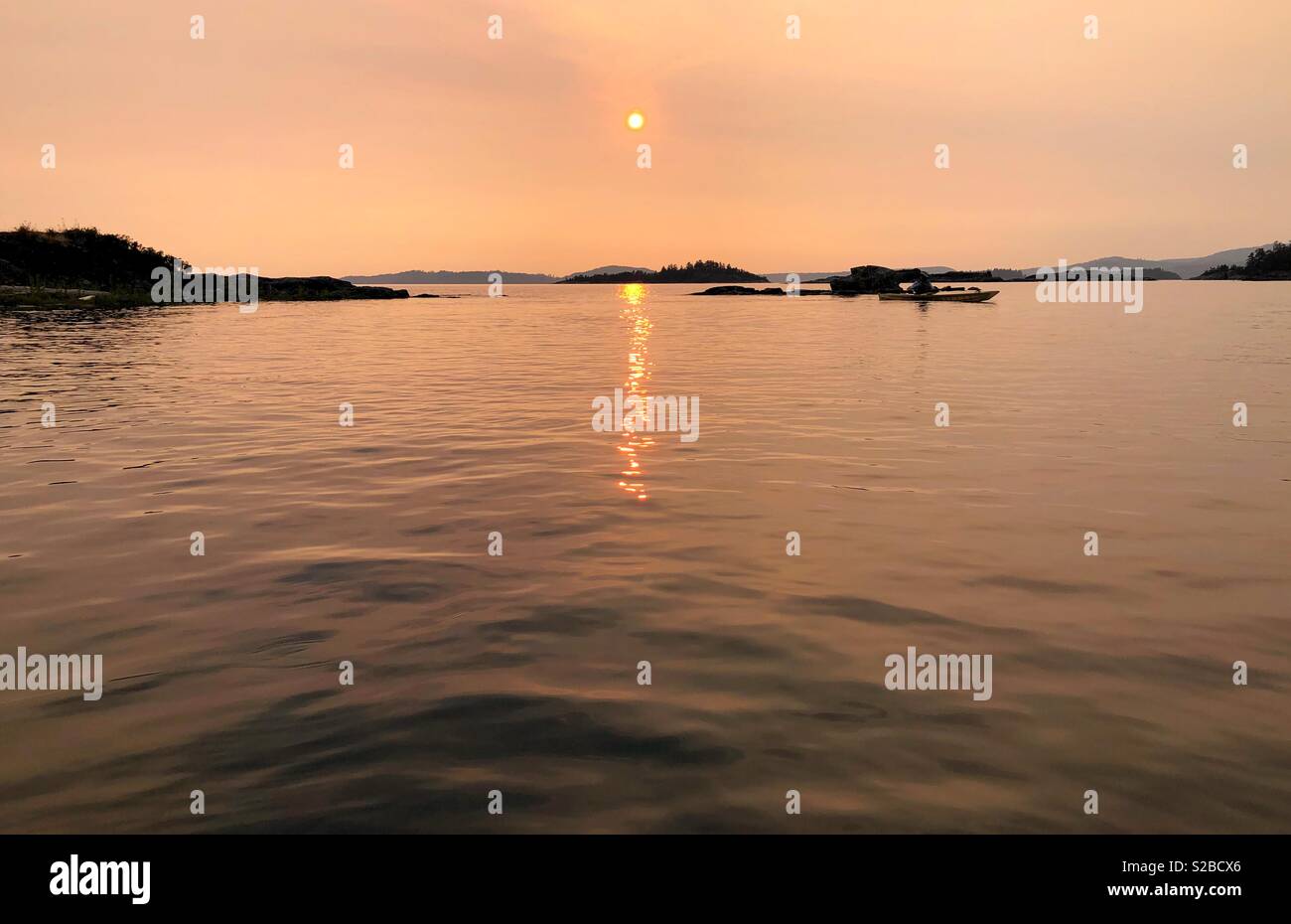 Kajak in Desolation Sound in Bc bei Sonnenuntergang während der Waldbrände Stockfoto