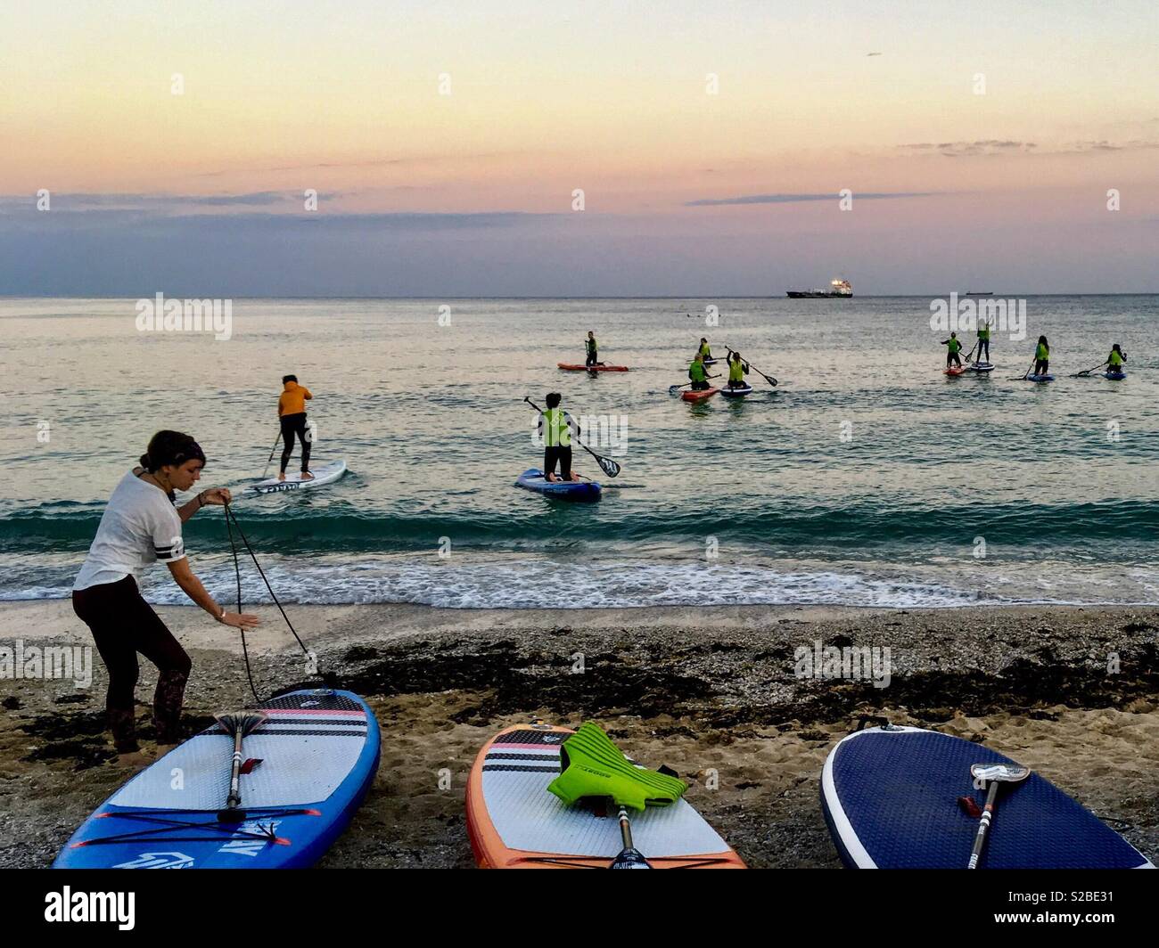 Eine Gruppe von paddleboarders gehen für einen Abend Paddel, Gyllyngvase Beach, Falmouth Stockfoto