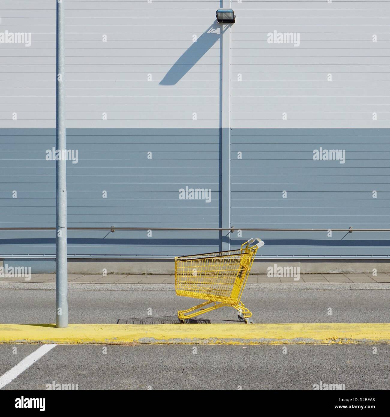 Gelber Einkaufswagen auf leerem Parkplatz - Konsumerismus - Alltag Stockfoto