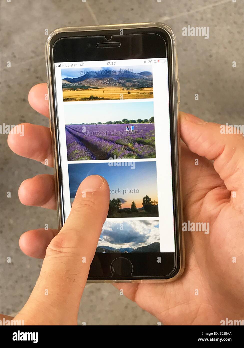 Mann anschauen Fotos in seinem Smartphone. - Smartphone-aufgenommenes Stockfoto