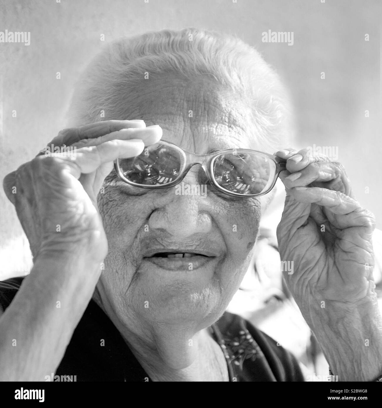 Schwarz-weiß-Porträt einer alten Dame ihre Gläser in Kuba einstellen Stockfoto
