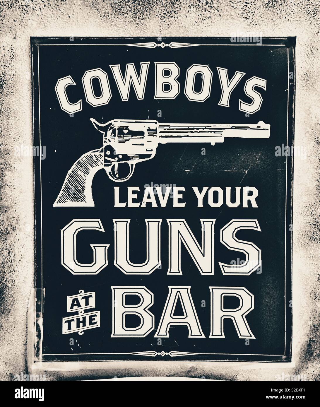 Schwarz mit Revolver Lesung "Cowboys lassen ihre Waffen an der Bar" - Smartphone-aufgenommenes Stockfoto