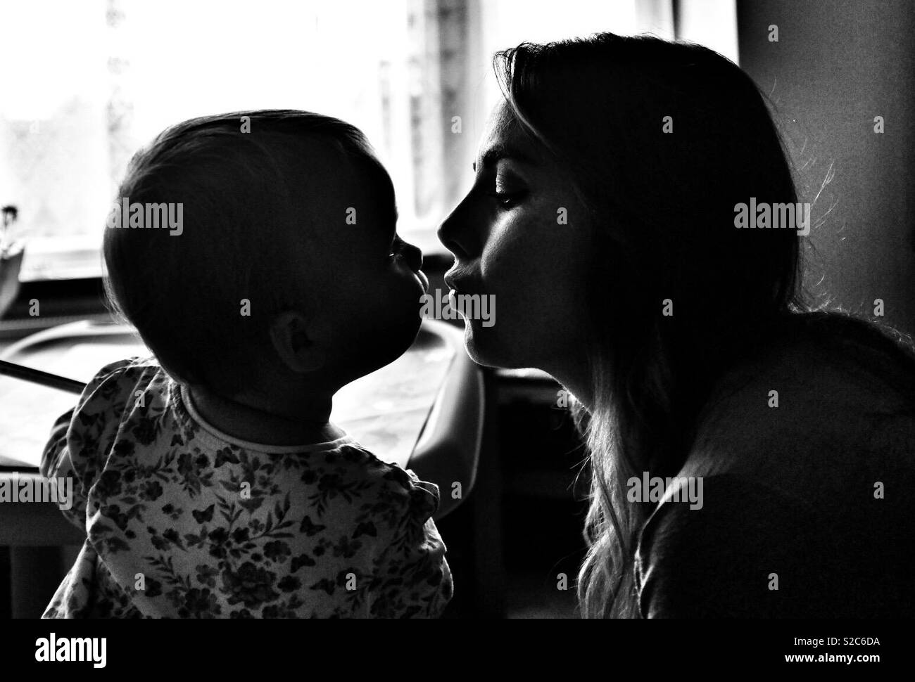 Mutter und ein Jahr alte Tochter Kuss mit Liebe Stockfoto