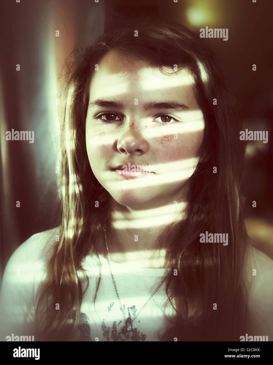 Portrait eines Mädchens mit Streifen von Licht über ihr Gesicht Stockfoto