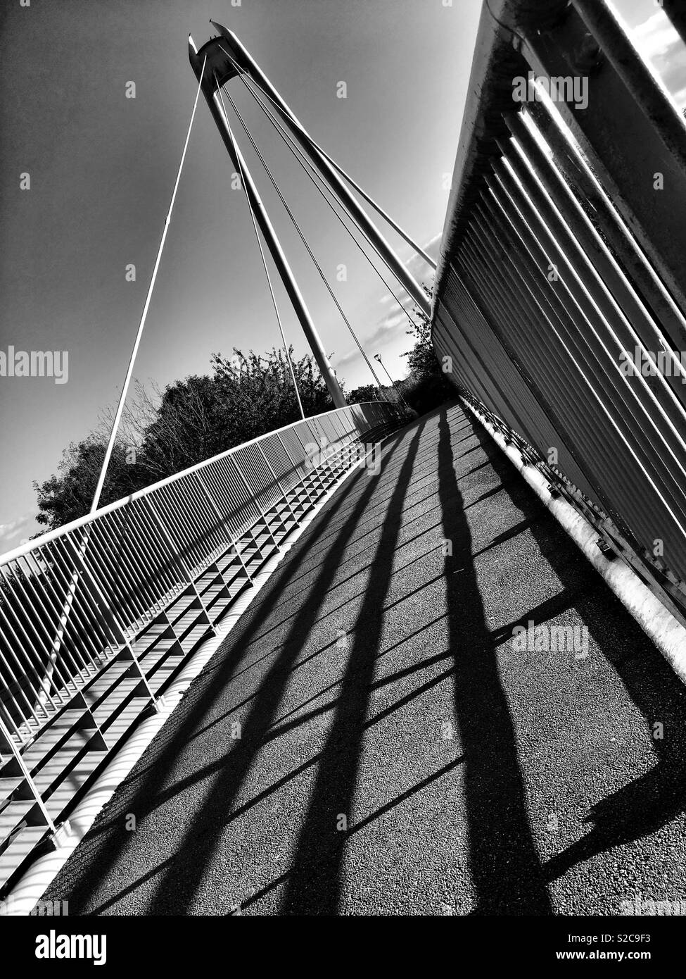 Schwarze und weiße Studie einer Fußgängerbrücke Gehweg mit starken Schatten Stockfoto
