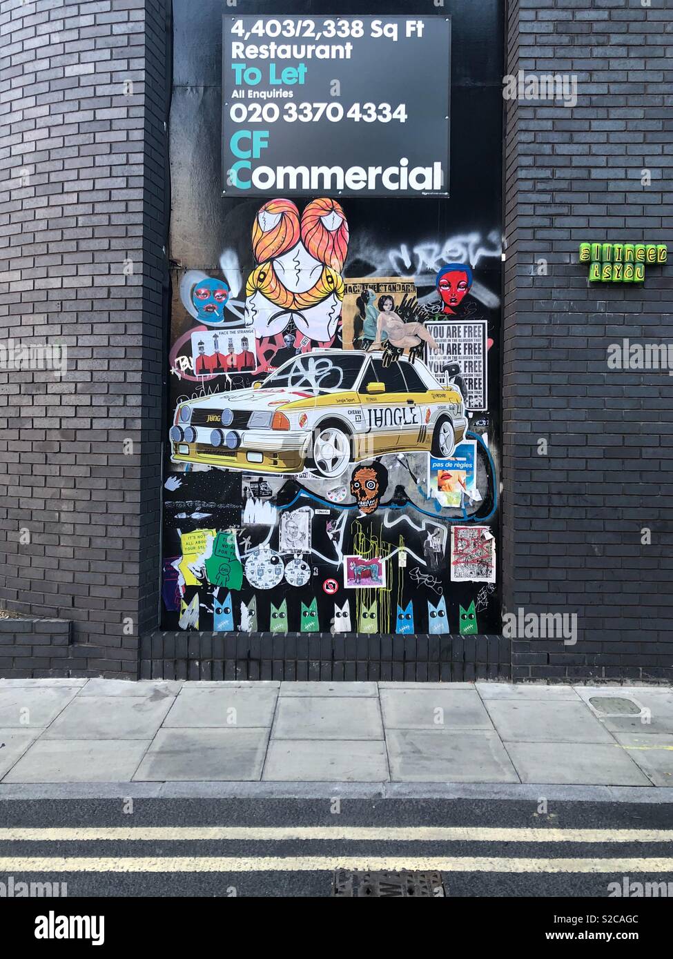 Street Art Collage zwischen dunklen Ziegelwänden in Shoreditch, East London Stockfoto