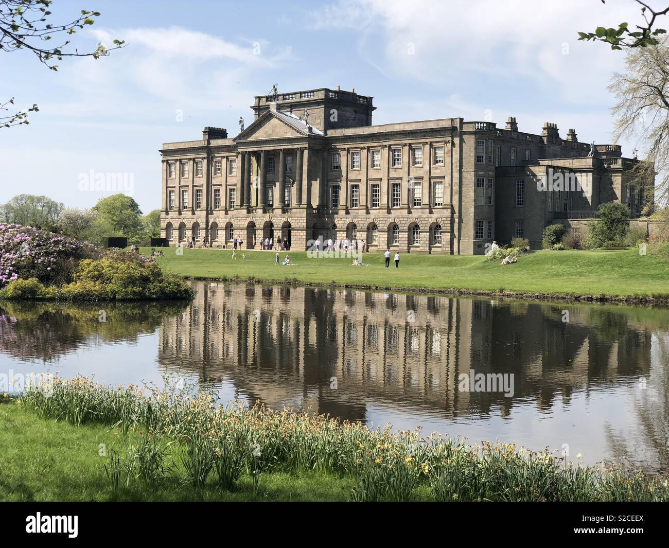 Ein beeindruckendes historisches Haus, das auf einem See wider. Stockfoto