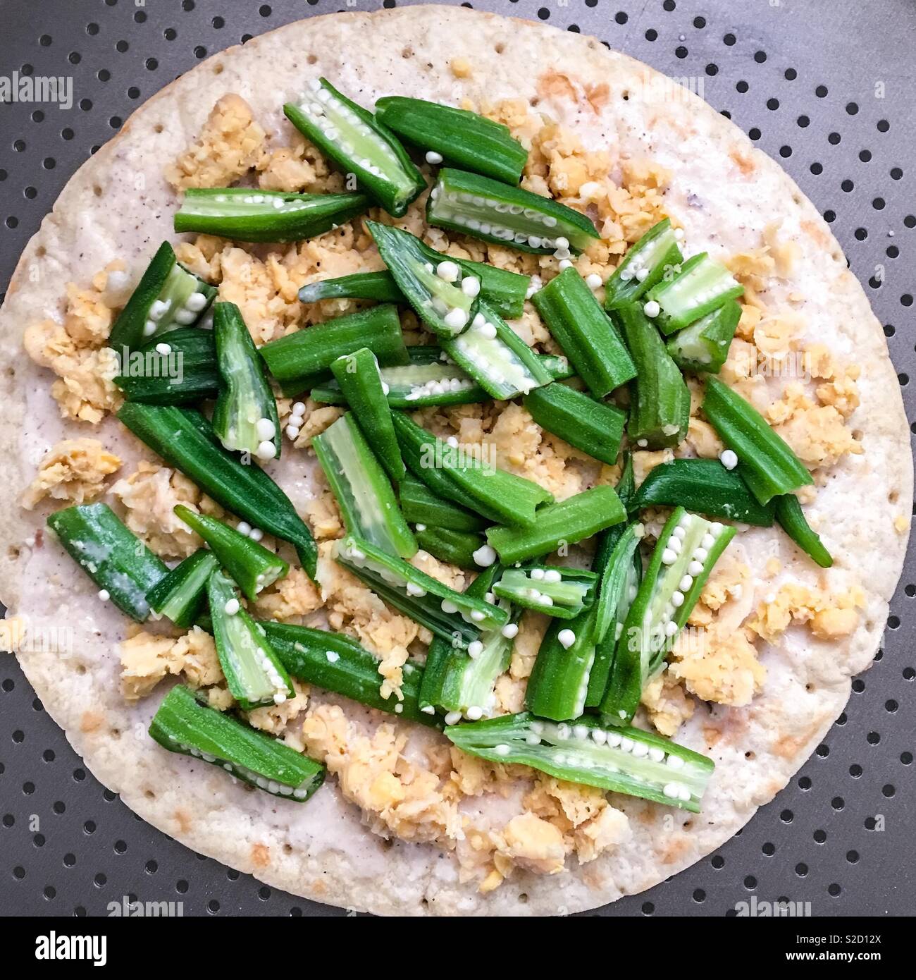 Hausgemachte glutenfrei Lactosefrei vegan weiße Pizza vor dem Kochen auf der Pfanne. Okra, Kichererbsen aka Kichererbsebohnen, vegetarisches Essen auf eine glutenfreie Kruste. Gesunde modernen Lebensmittelzubereitung. Stockfoto