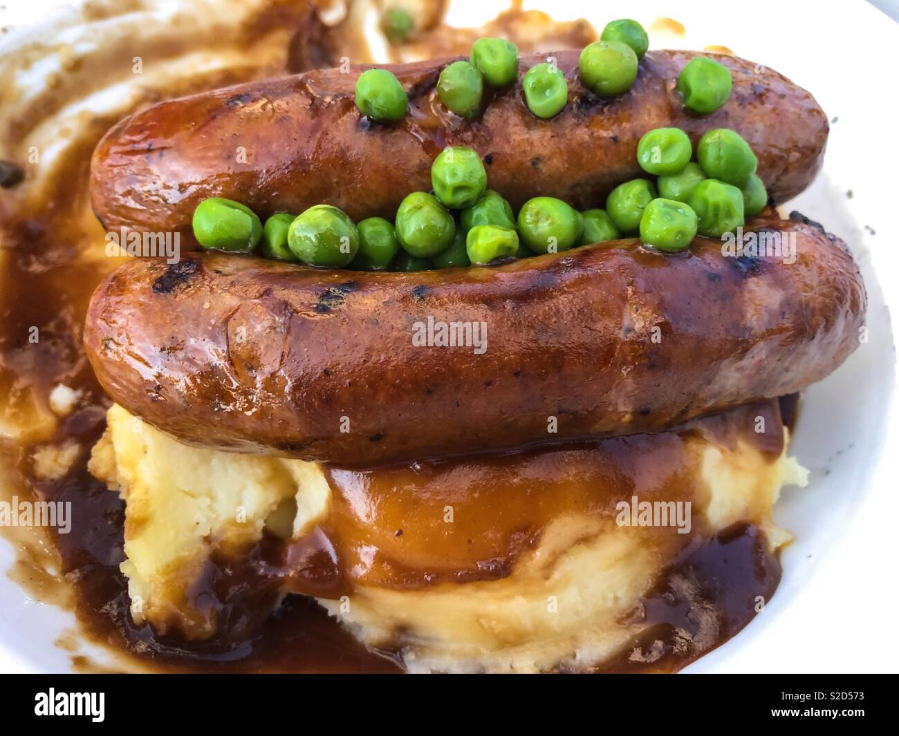 Würstchen mit Kartoffelbrei und Erbsen, die gemeinhin als Brei und Knallkörper in Australien. - Smartphone-aufgenommenes Stockfoto