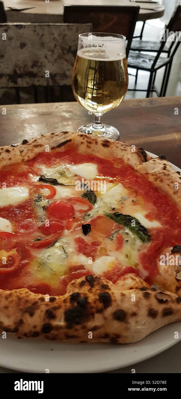 Original margherita Pizza mit einem Glas Bier Stockfoto