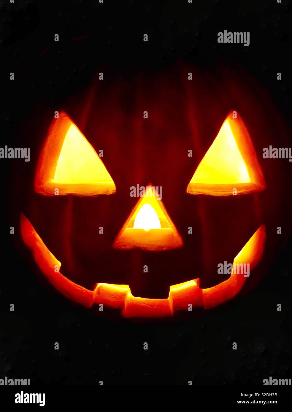 Traditionelle Jack o'Lantern lächelnd mit Licht in der Dunkelheit auf Halloween Stockfoto