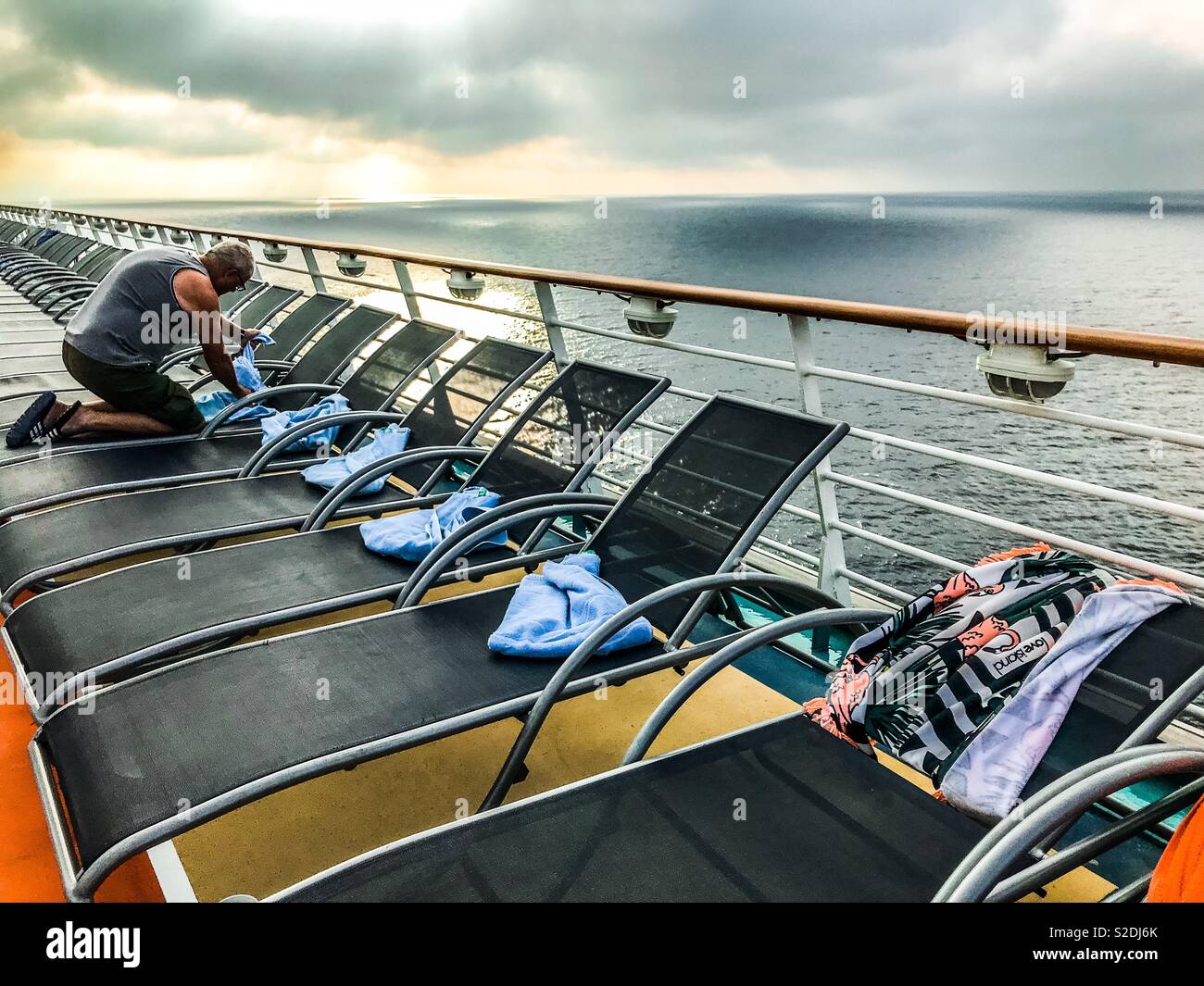 Früh am Morgen eine Sonnenliege Handtuch Platzierung auf Kreuzfahrtschiff Stockfoto