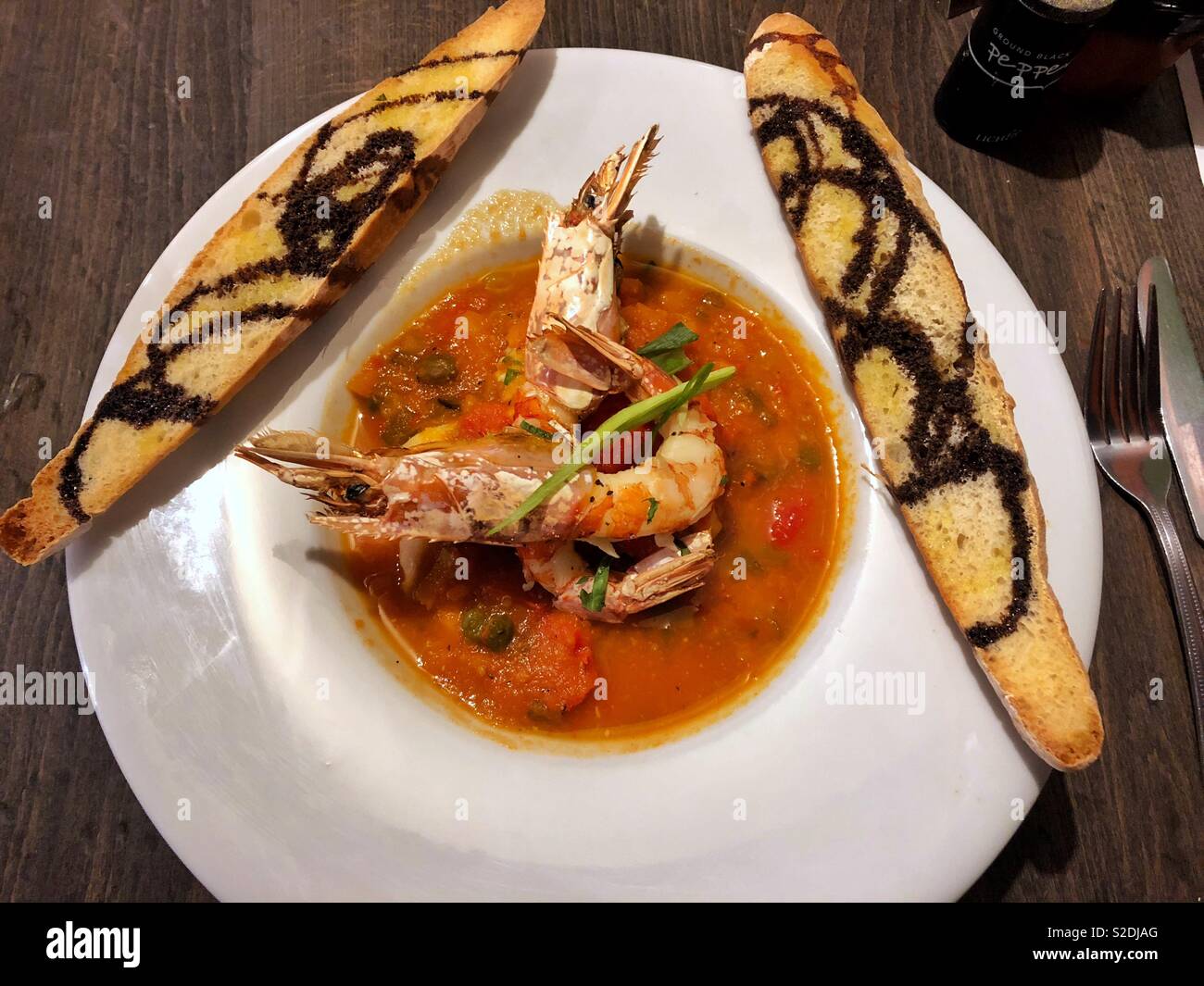 Meeresfrüchte Bouillabase mit Riesengarnelen und handwerklichen Baguette, England Art. Stockfoto