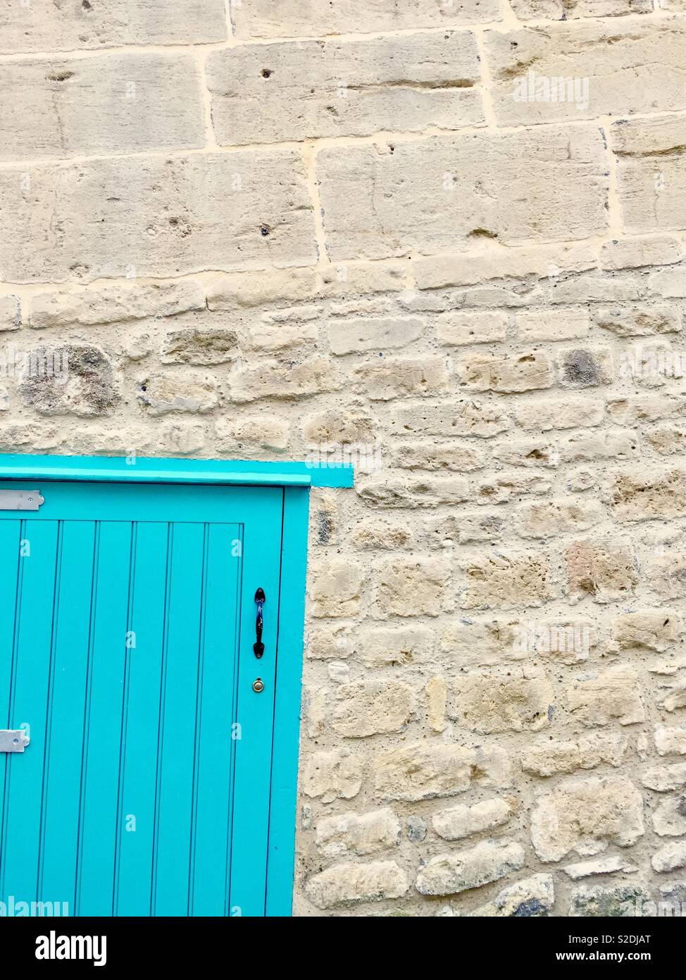 Türe aus türkisfarbenem Holz in einer Wand aus dem berühmten Bath Stone. Bath, Großbritannien. Stockfoto