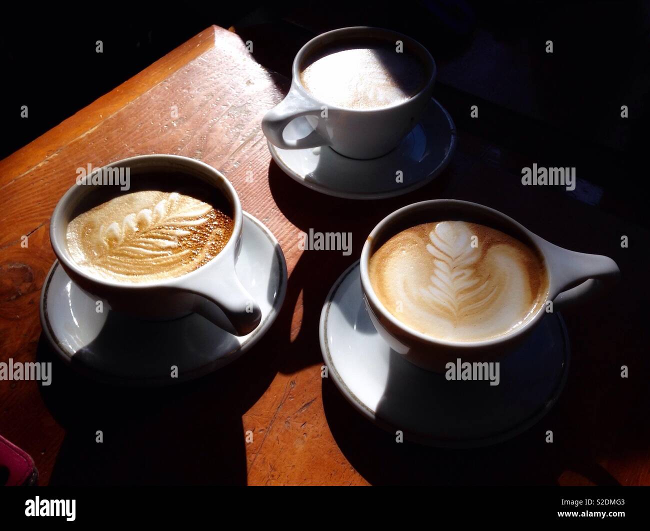 Querformat Foto von drei Fang Keramik Tassen Kaffee auf einem Holztisch, dunklen Vignette - Smartphone-aufgenommenes Stockfoto