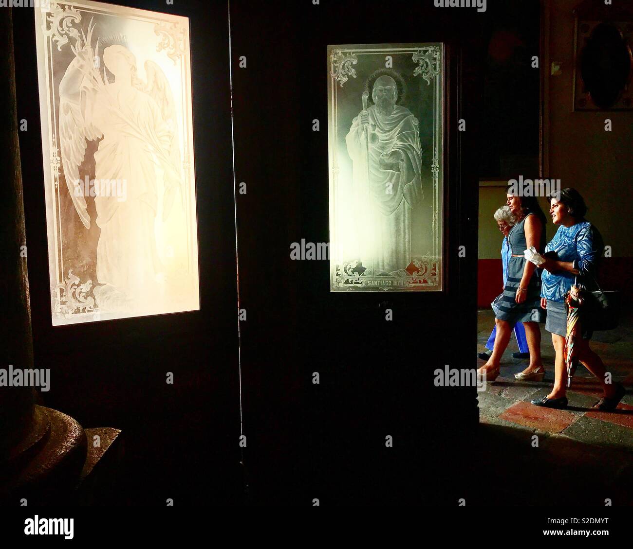 Menschen besuchen die Kathedrale von Oaxaca, Mexiko. Die Türen sind mit Glasfenster mit Heiligen und Erzengel eingerichtet. - Smartphone-aufgenommenes Stockfoto