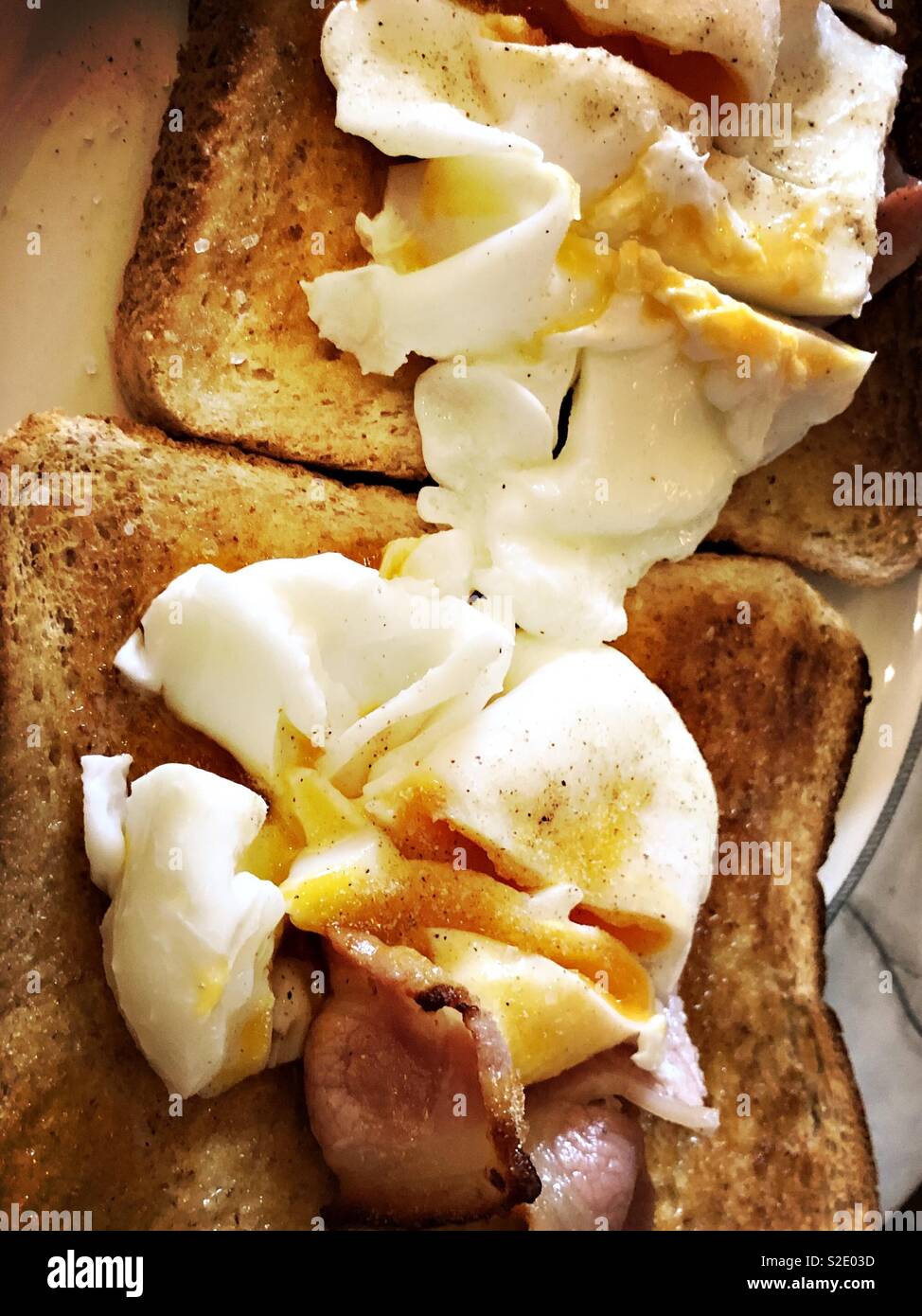 Pochierte Eier und Speck auf Toast Stockfoto