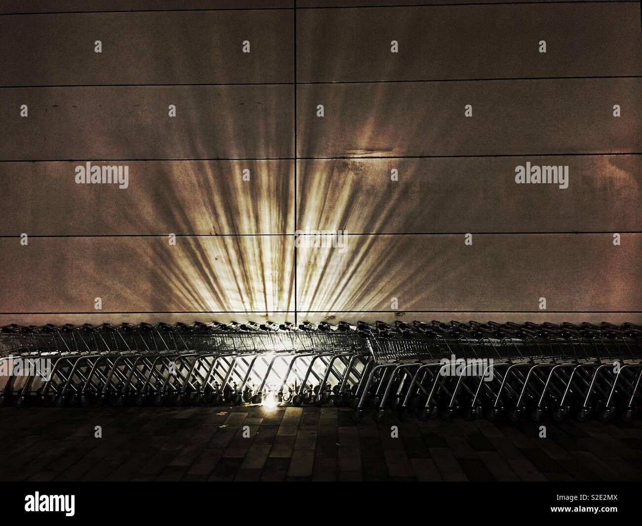 Lichtstrahlen durch Supermarkt Trolleys. Stockfoto