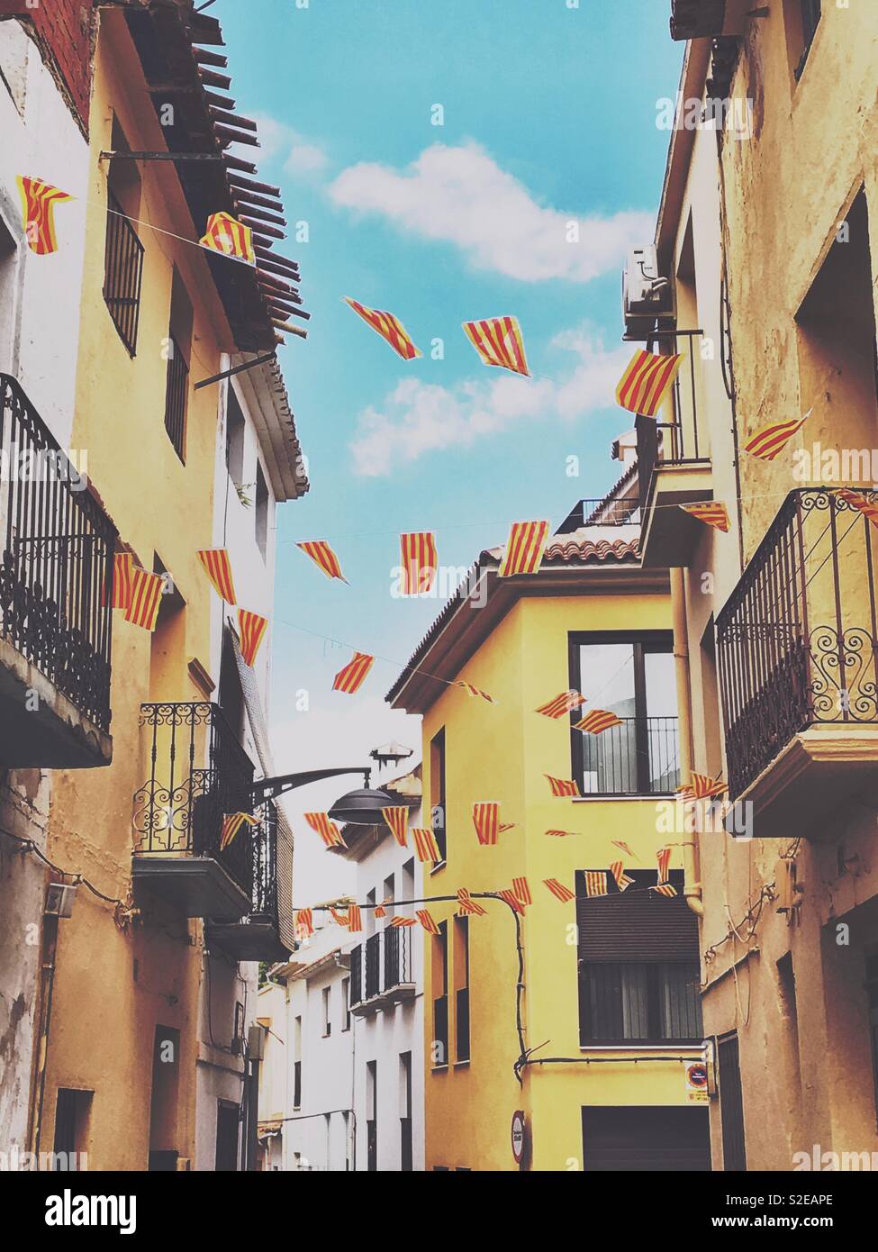 La Senyera, die unter der Flagge von Katalonien, schmückt eine Straße in der Provinz Alicante, Spanien. Stockfoto