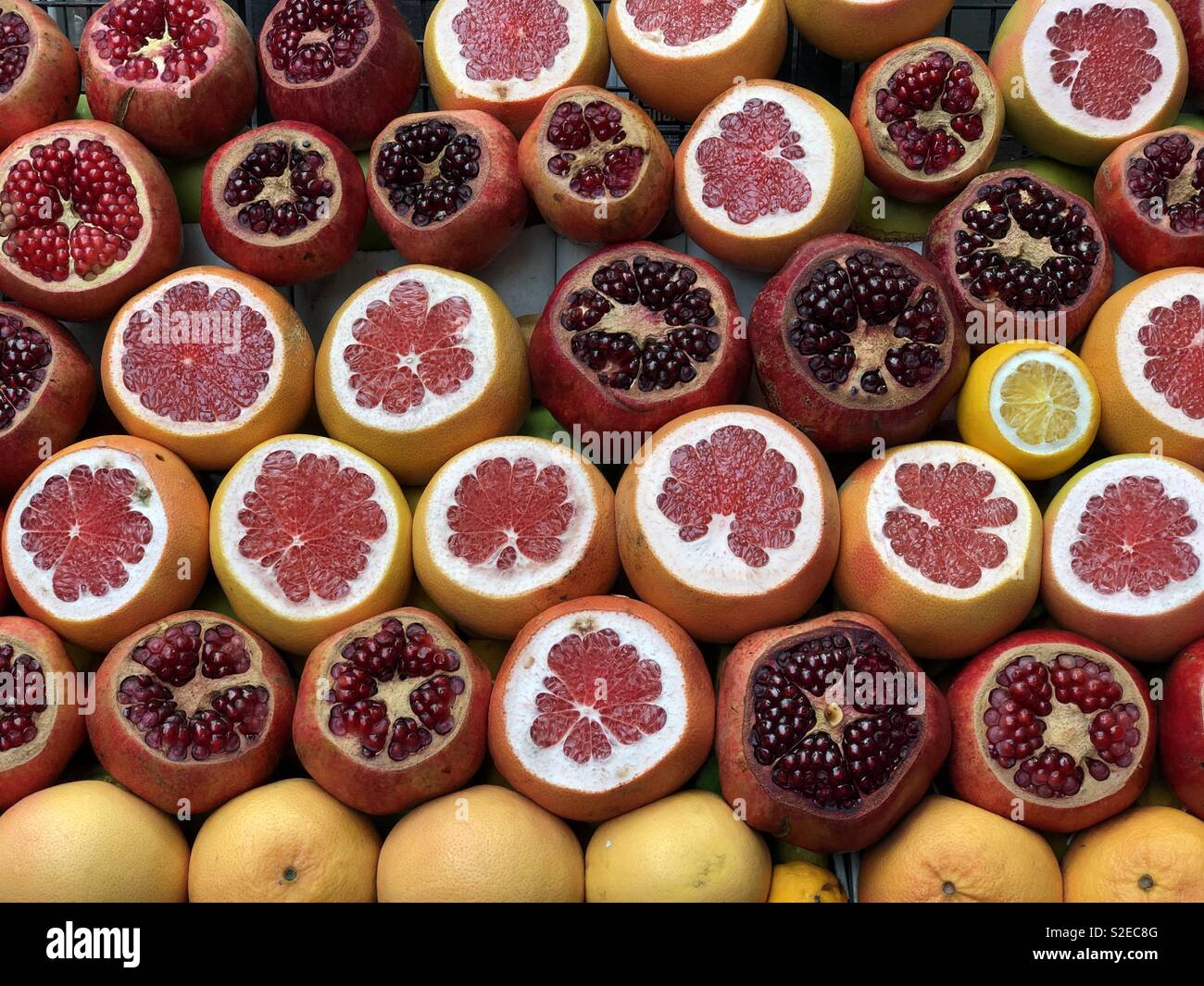 Frischer Saft shop, Detailansicht über abgehackte Granatäpfel, Orangen, Zitronen und Grapefruits - Smartphone-aufgenommenes Stockfoto