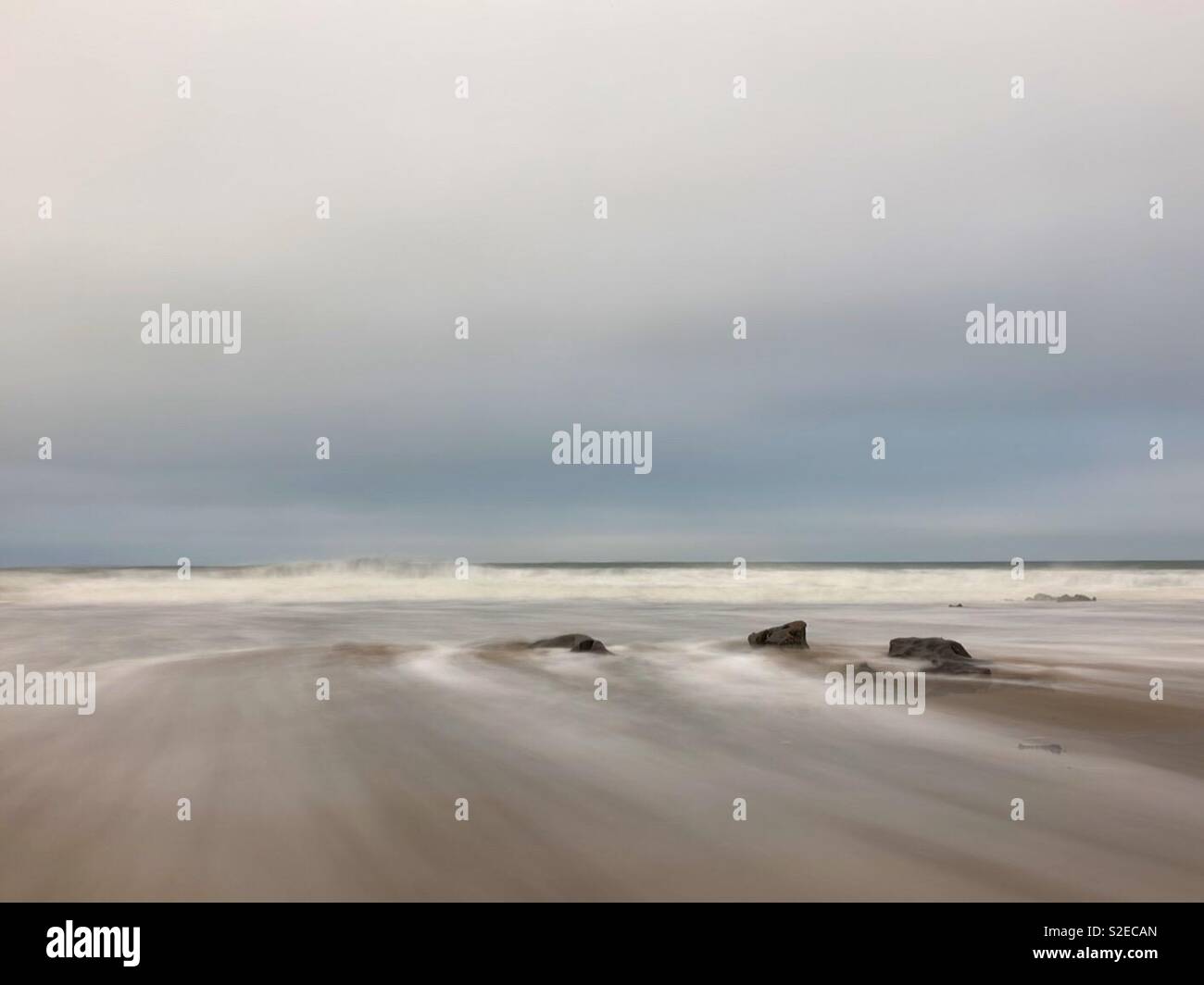 Wellen auf einem Waliser Strand, Morgen, November. Stockfoto
