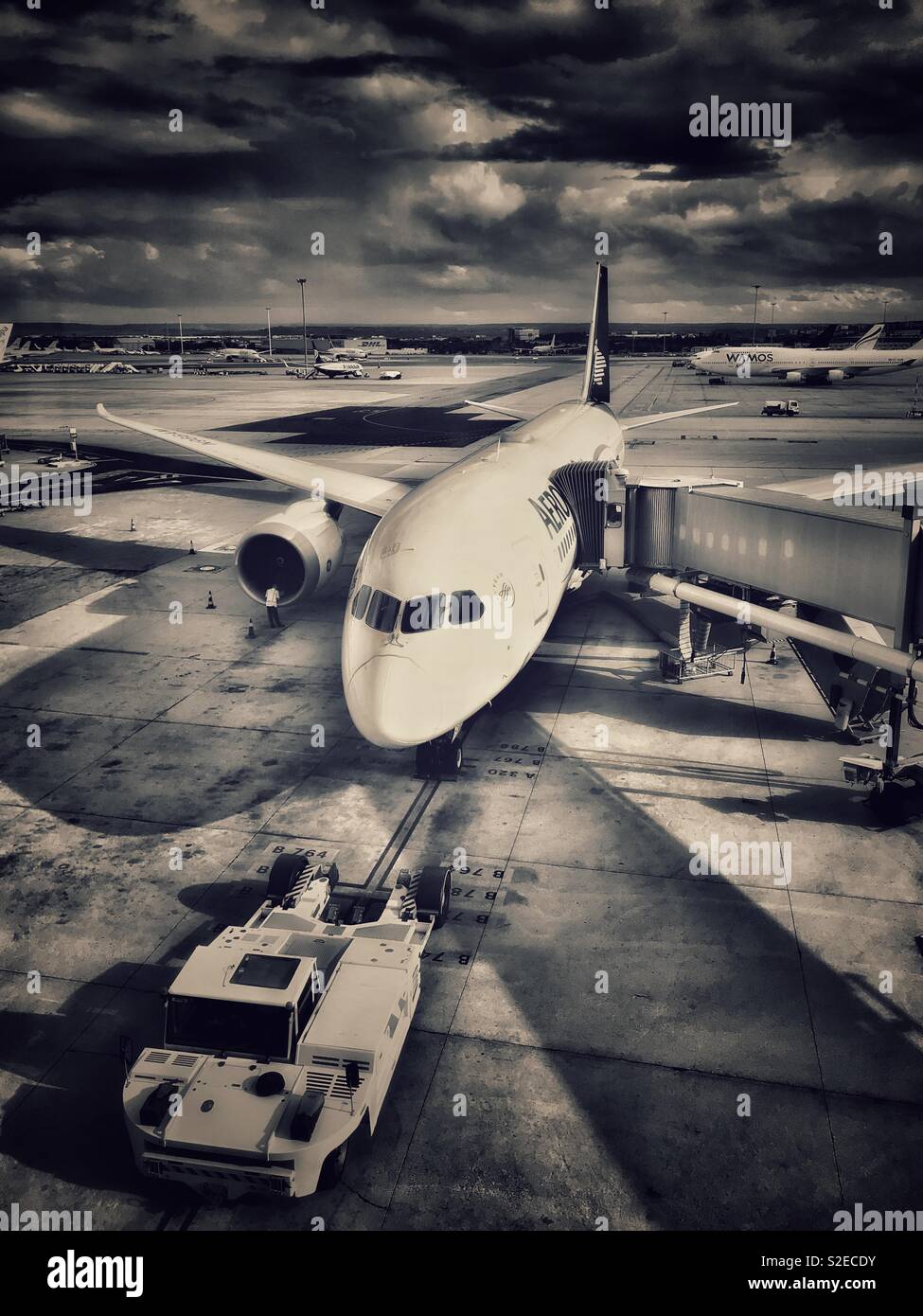 Ein Flugzeug sitzt unter Gewitterwolken am Flughafen in Europa. Hat dieses Flugzeug gerade angekommen? Ist es über Abzuweichen? Foto - © COLIN HOSKINS. Stockfoto