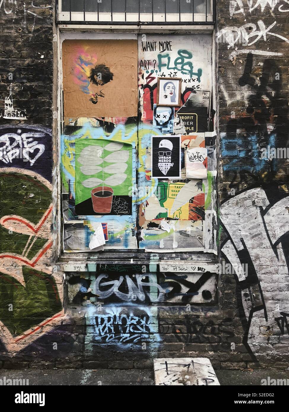 Möchten Sie mehr Kunst? Collage graffiti Streetart in Shoreditch, England. Auf alten industriellen Ziegelgebäude Stockfoto