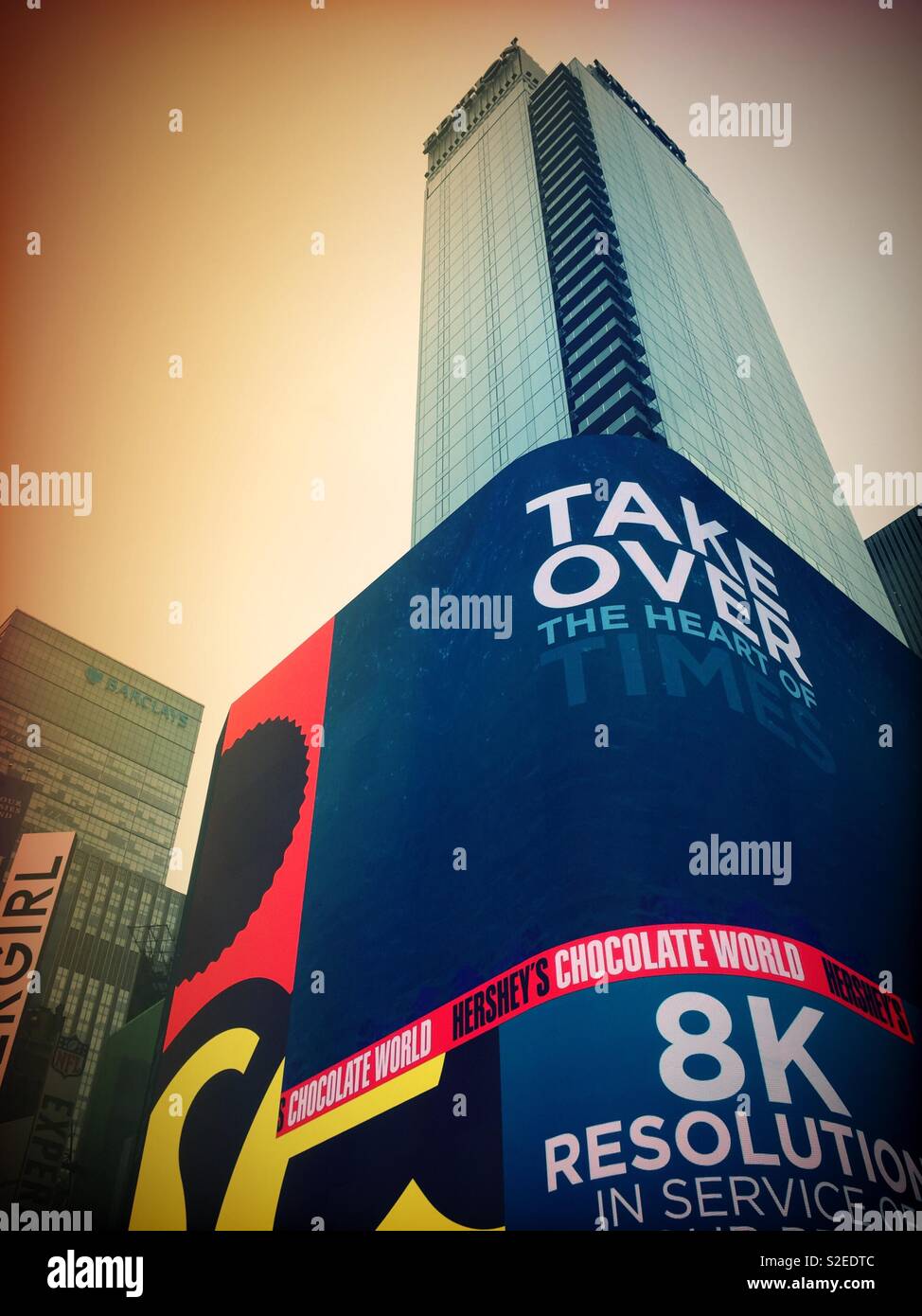 Eine riesige hell leuchtende LED-Bildschirm auf einem Glas Hochhaus in Time Square, New York City, USA - Smartphone-aufgenommenes Stockfoto