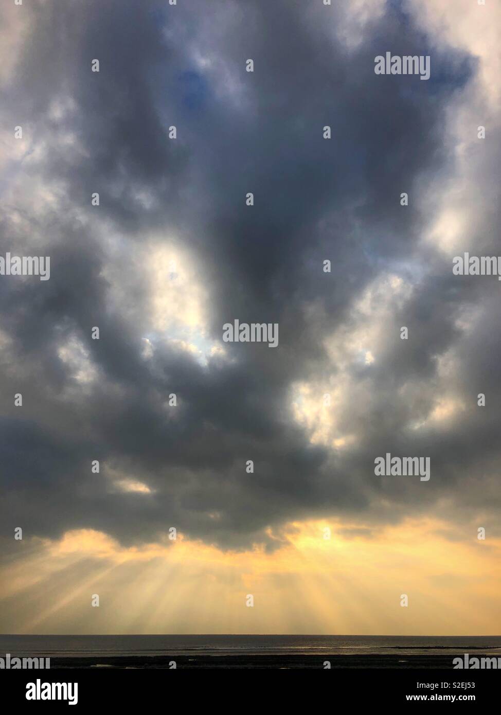 Dramatische Himmel mit Sonnenstrahlen über den Kanal von Bristol, November. Stockfoto