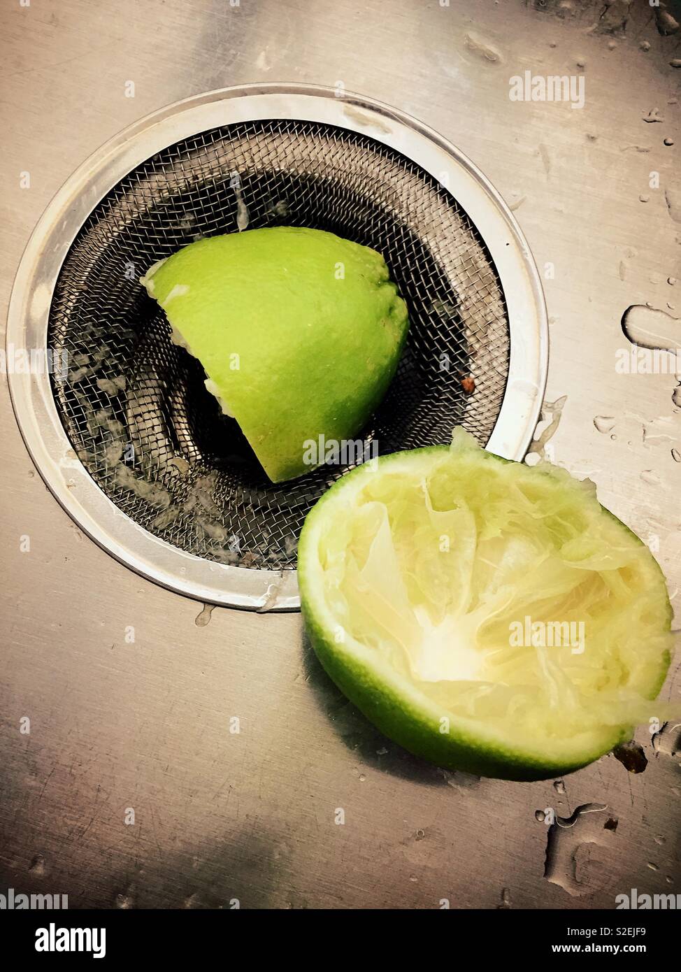 Noch immer leben von gepressten frische Limetten in einer Küche Abfluss im Waschbecken. Stockfoto