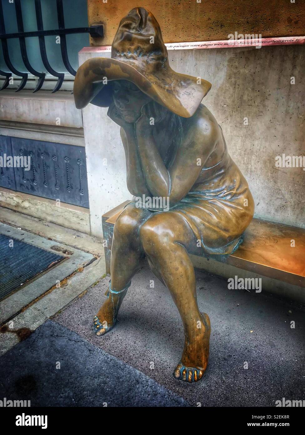 Frau sitzt Statue in Paris Frankreich - Smartphone-aufgenommenes Stockfoto